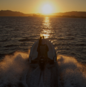 Amphibious vehicle navigating at sunset